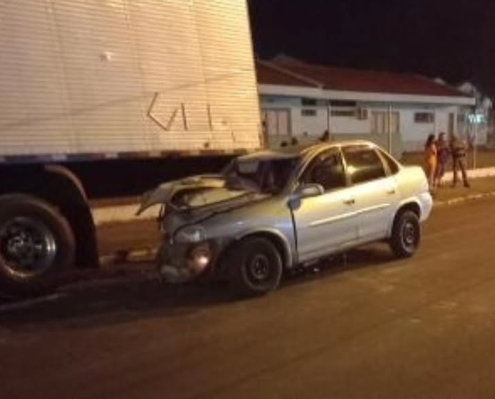 Parte do automóvel ficou presa embaixo do caminhão.