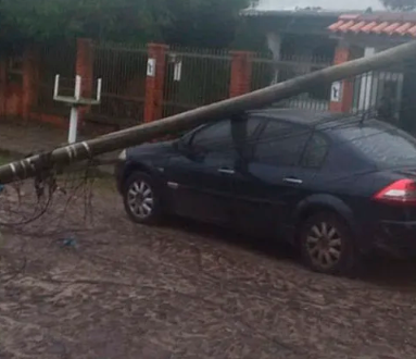 Carro foi atingido por poste que caiu devido a vendaval que atingiu a região.